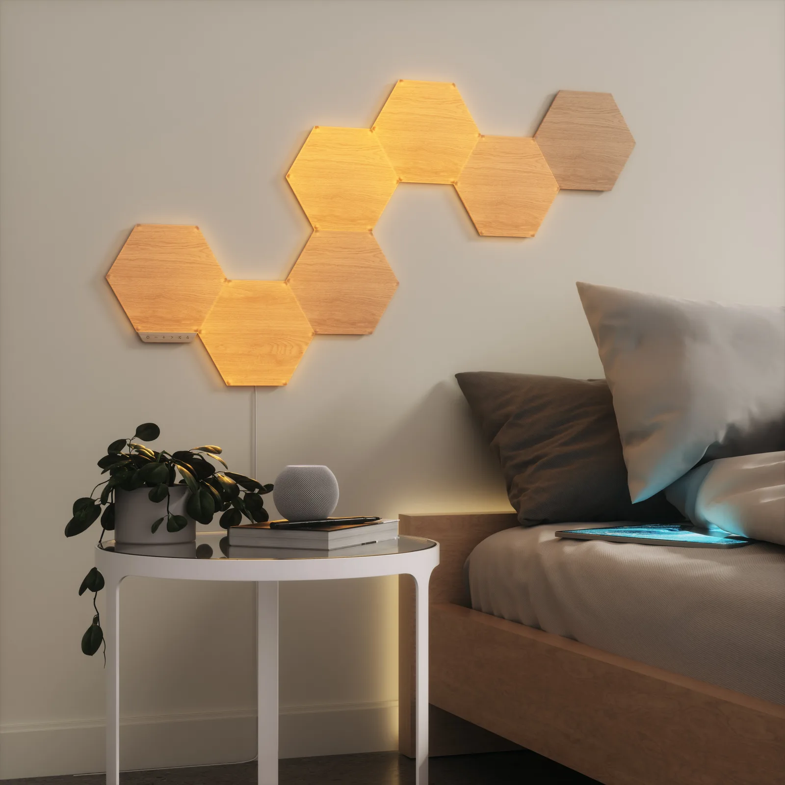 Panneaux hexagonaux Nanoleaf Elements effet bois allumés en lumière blanche chaude sur le mur d’une chambre
