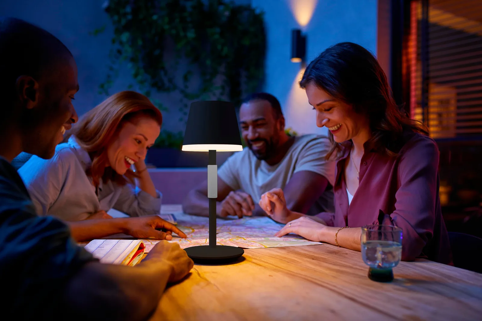 Lampe de table portable Philips Hue Go blanche avec poignée en silicone, posée dans un intérieur soigné