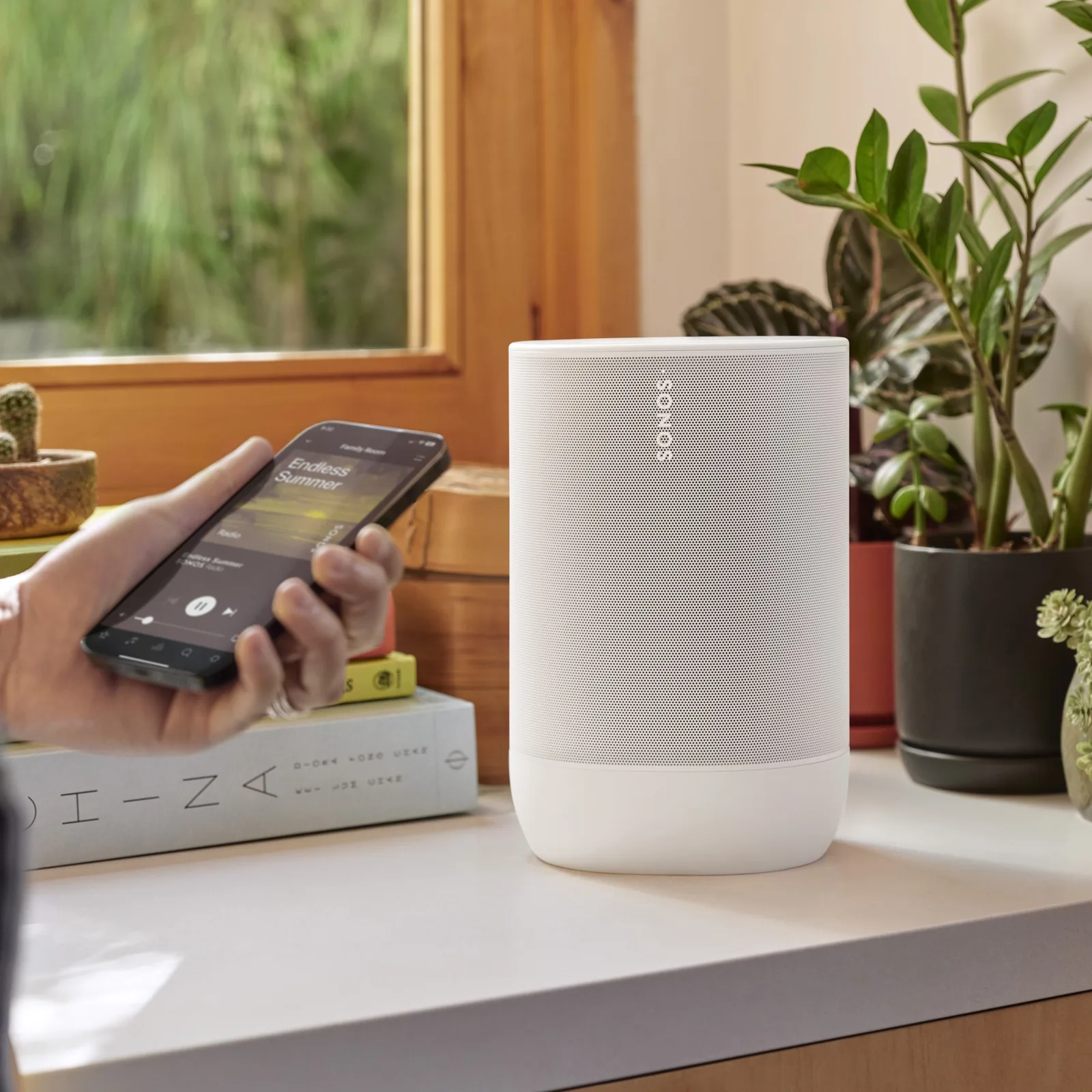 Enceinte Sonos Move 2 blanche posée sur un buffet à côté d'une plante — vue 2